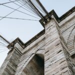 Touristen lieben Brooklyn Bridge wegen ihrer bemerkenswerten Aussicht und ihrer einzigartigen Architektur